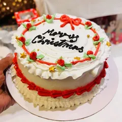 This vintage-style Merry Christmas cake is decorated with classic red and white buttercream frills, delicate roses, and green leaves. It’s a festive centerpiece for any holiday gathering.