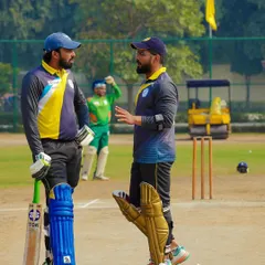 Discussing strategy with a teammate between overs. Just like in a legal case, communication and a clear plan are essential for success on the cricket pitch.