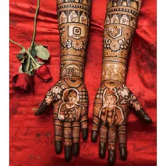Your mehendi is a key part of your bridal look. This design shows how custom portraits and story elements, like the Instagram logo with a special date, come together against a beautiful red lehenga.