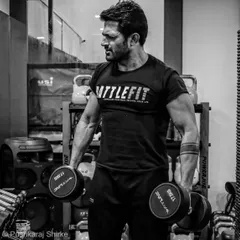 Holding 17.5kg dumbbells, focusing on building strength. As a coach, I believe in walking the talk and putting in the work myself.