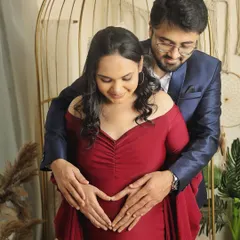 A classic couple's pose where both partners gently hold the baby bump, forming a heart with their hands. It’s a simple yet powerful way to symbolize their love for the baby.
