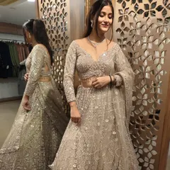 The model smiles in this gorgeous beige lehenga, showing how comfortable and glamorous you can feel in one of my pre-loved designer pieces.