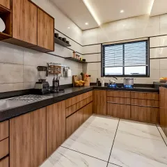 This L-shaped kitchen features beautiful light wood cabinets and a dark, textured countertop. The design includes open shelving for easy access to everyday items and ample storage, creating a functional and aesthetically pleasing cooking space.