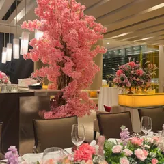 A stunning faux cherry blossom tree serves as a major focal point for this restaurant decor. Paired with a long floral tablescape, it transformed the space into a pink wonderland for a special celebration.