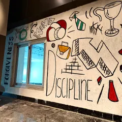 The "Discipline" and "Forgiveness" section of the doodle mural. I used a freehand, illustrative style to fill the wall with symbols related to success, hard work, and personal development, making the space more dynamic and thought provoking.