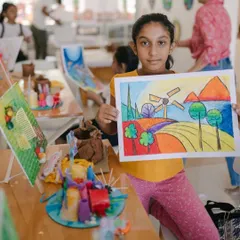 This young artist is thrilled with her colorful landscape drawing and other camp creations. Our camps help build confidence by allowing kids to explore different styles, like this piece using oil pastels.