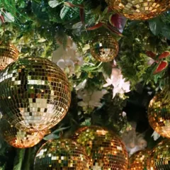 Decor is incomplete without looking up. A ceiling installation of disco balls mixed with greenery adds a layer of glamour and fun to the entire party space.