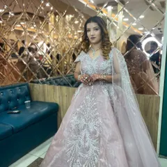 The client poses in our salon, showcasing her complete look against our signature mirrored wall. The soft lighting highlights the shimmer in her makeup and the sparkle of her gown.