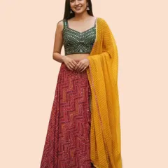 A beautiful and bright lehenga perfect for a festive night. This model wears a red chevron-printed skirt with a green mirror-work blouse and a contrasting yellow striped dupatta.