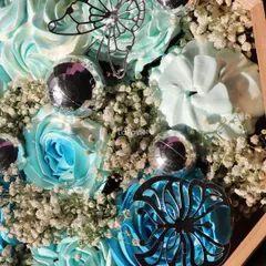 A detailed macro shot of the silver butterfly and floral details on these custom cupcakes.