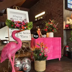 A chic setup for a 'Fierce & Fierce' 40th birthday, featuring a pink flamingo, disco balls, and a bright pink cabinet for a pop of color.