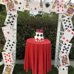 A creative and playful cards-themed party arch. I used a white garden trellis and decorated it with oversized playing cards to create a unique photo spot and cake display area.