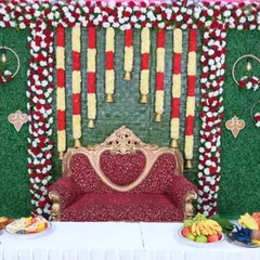 A closer look at the traditional Seemantha backdrop, showing the detail in the floral garlands and the woven coconut leaf mat.