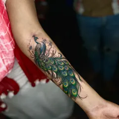 We love working with color, and this peacock forearm tattoo is a great example. The vibrant greens and blues bring the design to life, creating a beautiful and eye-catching piece that flows with the arm's natural shape.