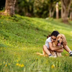 A girl shares a heartfelt hug with her Cocker Spaniel in a lush green park. The bond between children and their pets is so pure, and it's an honor to freeze these moments of friendship in time.