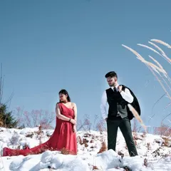 A quiet, reflective moment on a snowy hilltop. This shot captures a different kind of intimacy, one that is thoughtful and serene, with the vastness of the mountains reflecting the depth of their bond.