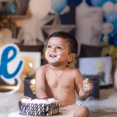 A big, frosting-covered smile from this happy baby boy during his blue-and-white themed cake smash photoshoot.