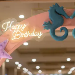 A close-up of the "Happy Birthday" neon sign from our Baby Shark party. Paired with a custom seahorse prop, this detail helped create a fun and vibrant under-the-sea atmosphere.