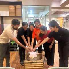 We believe in celebrating together. The WellFlow team and members join hands, symbolizing the unity and supportive energy of our studio.