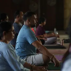 A close-up of students in seated meditation. This image reflects the grounding and transformative power of the practice, a journey that unfolds both within and beyond the mat.
