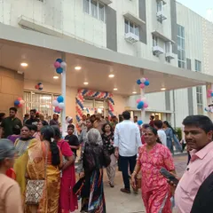 The entrance of the Home for the Aged, bustling with community members during its opening ceremony. The covered entryway provides a welcoming and accessible transition into the building for residents and visitors.