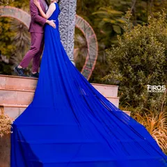 This angle captures the incredible length and drama of the royal blue trail gown. It’s a cinematic shot that emphasizes both the fashion and the romantic connection of the couple.