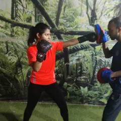 Precision and power are honed through dedicated practice. This image captures an intense moment of pad work, focusing on boxing combinations to improve speed, accuracy, and defensive reflexes.
