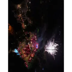 A perfectly timed aerial photograph capturing the fireworks display at a night wedding. This perspective shows the entire venue lit up by the celebration.