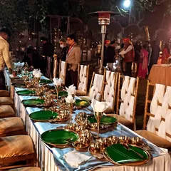 An intimate dinner setup at Sajjan Court, showcasing a long table with elegant green and gold tableware. This arrangement is perfect for creating a royal and personal dining experience for close relatives and special guests.