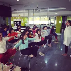 Guiding employees through gentle chair yoga stretches. These movements are designed to release tension in the neck, shoulders, and back that comes from sitting at a desk.