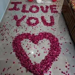 For a grand romantic gesture, I spell out 'I LOVE YOU' on the floor using fresh rose petals, with a large heart shape below it.