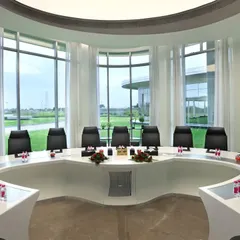 A futuristic, circular boardroom with a custom-designed conference table. The expansive windows flood the space with natural light and provide an unobstructed view, creating a powerful setting for high-level meetings.