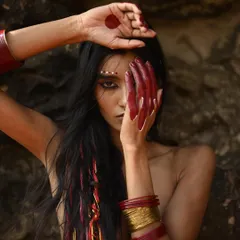 A raw, powerful look for an outdoor editorial. I used red body paint on the hands and graphic white dots on the face to create a tribal-inspired aesthetic, complemented by long, natural hair.