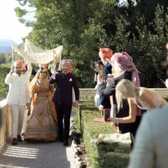 The bride's grand entrance under a phoolon ki chadar, with the beautiful Italian landscape in the background. A perfect blend of Indian tradition and international destination beauty.