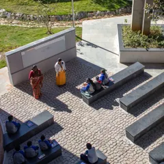 An outdoor classroom at Euro School, Bannerghatta, where learning happens on stone benches amidst nature. We design these spaces to ground education in the real world, using natural textures and open air to stimulate the senses.