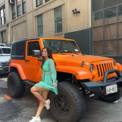 Posing with a cool orange Jeep in NYC. I always look for unique photo opportunities that capture the vibe of the city.