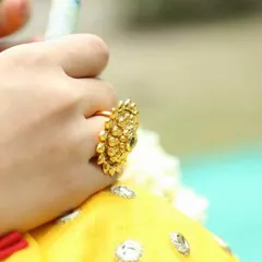 A traditional wedding ring with an adjustable band. This large, gold-plated floral ring is studded with polki stones, making it a perfect statement piece for your hand.