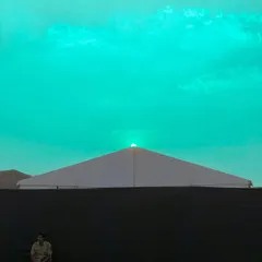 A surreal, color-shifted version of the sunset scene, with the sky turned a bright, unnatural turquoise.