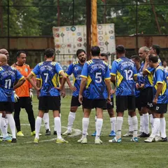 A tactical team huddle during a crucial moment in an 11-a-side game. Strategy and teamwork are at the core of how we approach every match in the Mumbai veterans league.