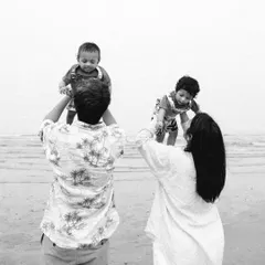 A beautiful silhouette-style shot of parents lifting their twin babies at the beach, creating a stunning family portrait.