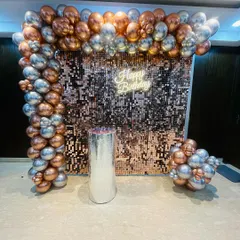 A beautiful rose gold and silver shimmer wall setup. The metallic balloons in the arch perfectly complement the sparkling backdrop for a very glamorous effect.