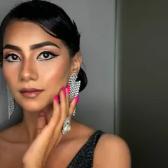 A full view of the finished graphic liner look, complete with flawless skin and a retro-inspired hairstyle. This is a perfect example of a complete party or editorial look.