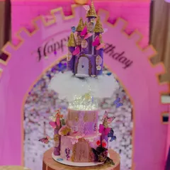 A closer look at one of my rotating castle cakes. This purple and pink masterpiece features multiple tiers, sparkling lights in the center, and is adorned with butterflies, creating a magical, fairytale effect.