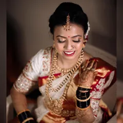 A beautiful portrait of the bride, Lavanya, looking serene and elegant in her white and red wedding saree.
