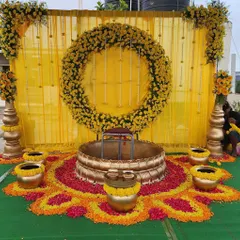 A Haldi ceremony should be full of joy and vibrant color. I created this beautiful outdoor setup using marigold flower arrangements, a traditional brass *urli* for the ceremony, and a bright yellow backdrop to make the photos look stunning.