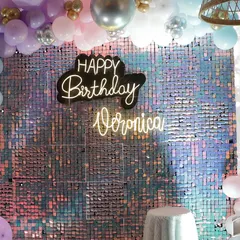 A vibrant and iridescent sequin wall serves as the backdrop for Veronica's 10th birthday. The custom neon sign and pastel balloon arch add a fun, youthful touch to the glamour.
