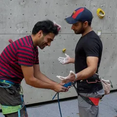 An instructor demonstrates the proper way to tie into the rope for lead climbing. Mastering these fundamental safety skills is crucial before you start climbing.