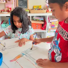Two friends collaborating on a beautiful watercolor dragonfly painting. Our personalized classes allow children to explore specific interests and techniques.