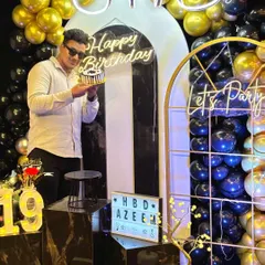 Celebrating the big 1-9. This young man poses with his cake in front of a stylish black, white, and gold decor theme, complete with neon signs. Our setups are perfect for creating those cool, Instagram-worthy birthday shots.