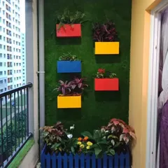 Think outside the box with artificial turf. Here, we used it as a textured wall covering, mounting colorful planters directly onto it for a fun and unique balcony feature.
